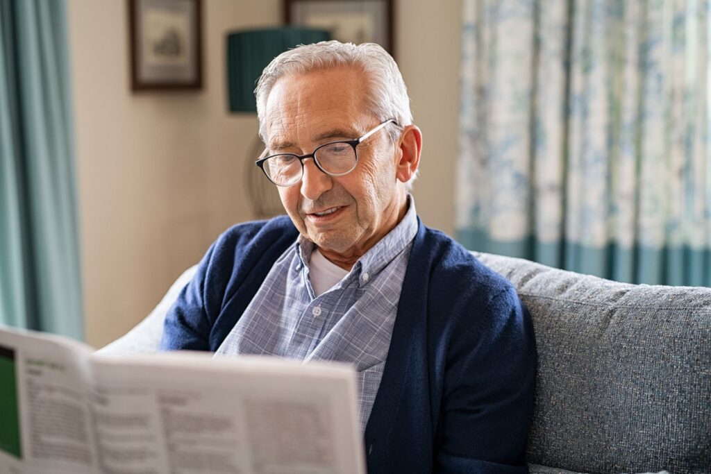 Älterer Mann liest entspannt Zeitung